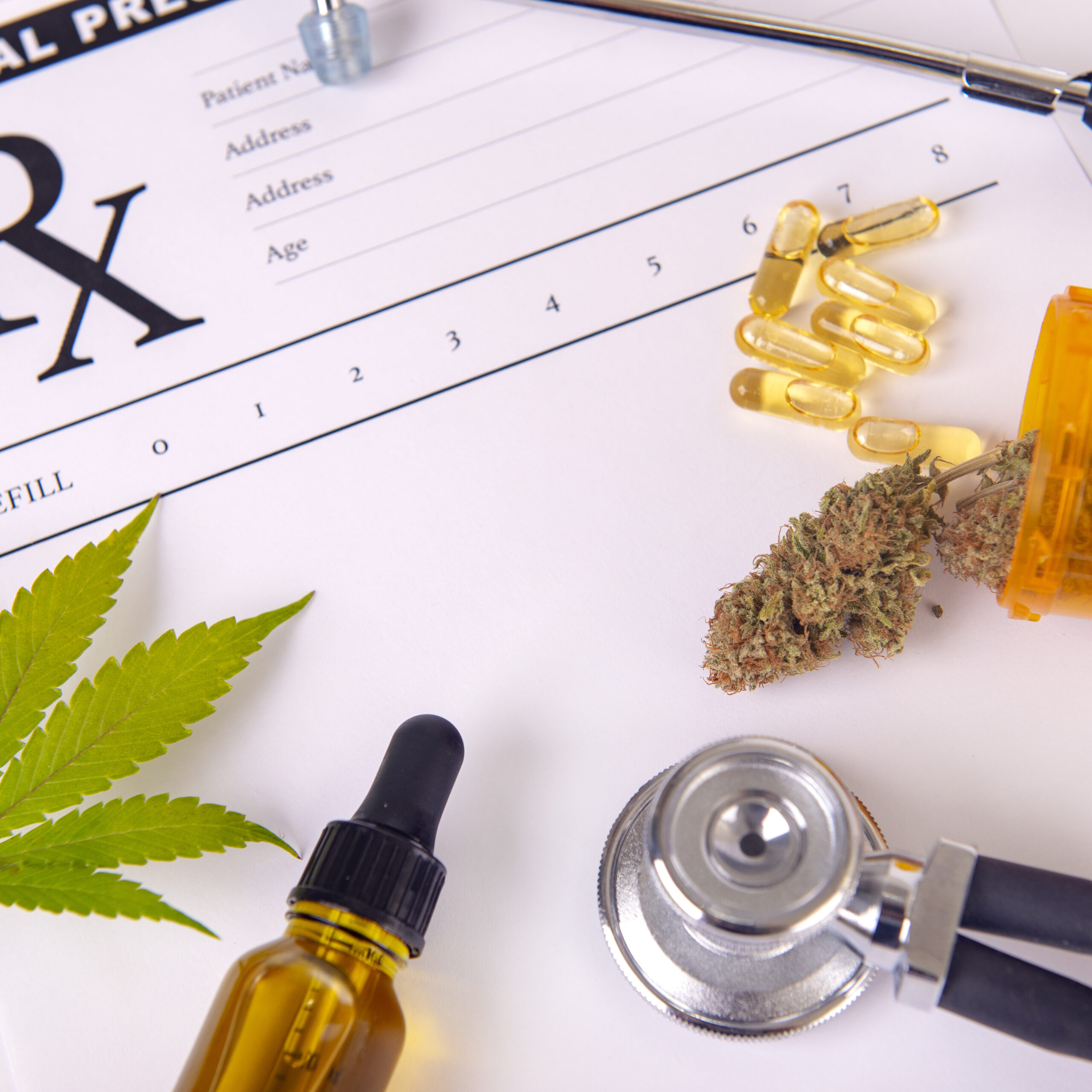 Assorted cannabis products, pills and cbd oil over medical prescription sheet - medical marijuana concept